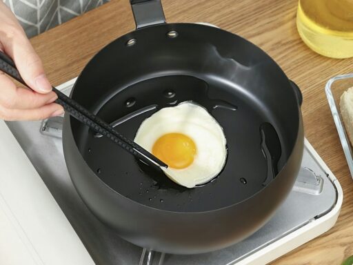 person cooking egg on black frying pan