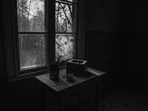 A black and white photo of a table in an abandoned house